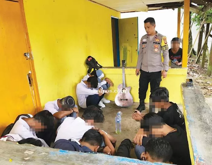 JANGAN DITIRU: Bhabinkamtibmas Manggar Baru Aipda Ahmad Hasanuddin mengamankan para pelajar yang asyik menenggak miras oplosan di Pantai Nelayan. IST.