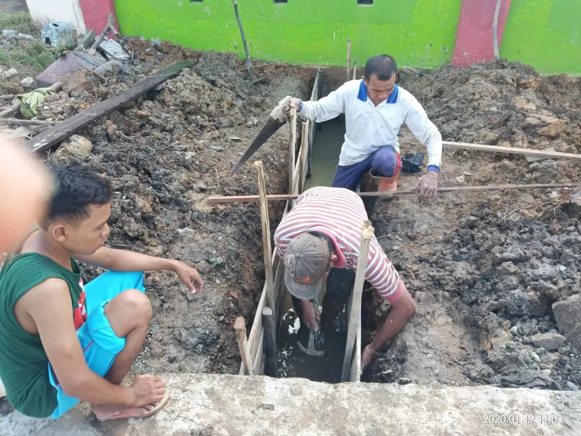 INISIATIF ORANGTUA: Beberapa orangtua pelajar SD 003 Tanjung Redeb tengah membangun saluran air menuju drainase di pinggir jalan.