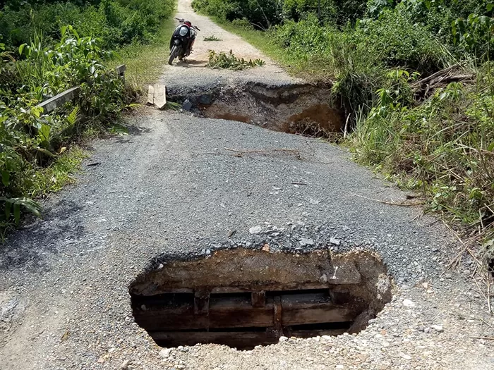 NYARIS PUTUS: Jalan yang merupakan akses menuju lahan pertanian di Kampung Buyung-Buyung nyaris putus.