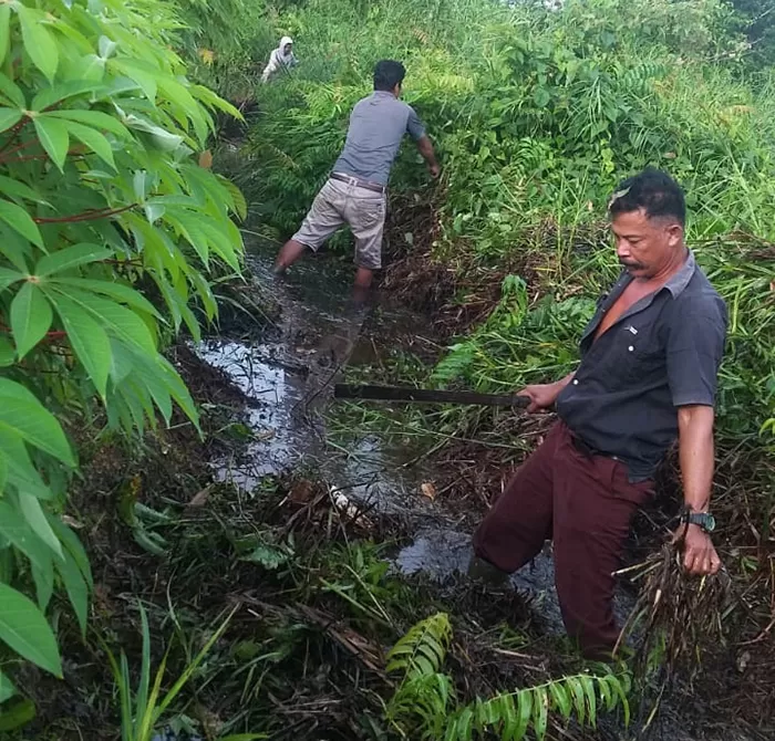 GOTONG-ROYONG: Beberapa warga RT 8, Kelurahan Gunung Tabur sedang membersihkan semak belukar yang menutupi drainase di Jalan Aji Putri Nural pada Minggu (9/2).