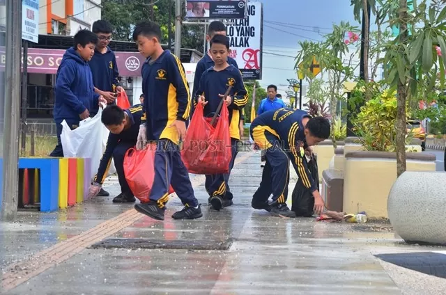 KOMPAK: Sejumlah anak didik SMP 1 Tanjung Redeb melaksanakan bersih-bersih sampah di Jalan SA Aminuddin, kemarin (21/2).