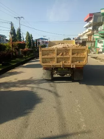TANPA PENUTUP: Salah satu truk pengangkut tanah tanpa menggunakan penutup melintas di Jalan Pulau Panjang.