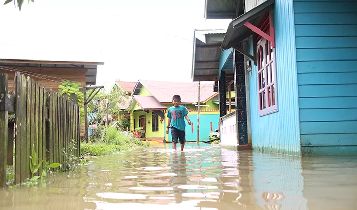 MASUK TERAS: Air hujan yang meluap dari drainase sampai memasuki teras rumah warga di wilayah Gang Ketapi, Tanjung Redeb, kemarin (26/2).