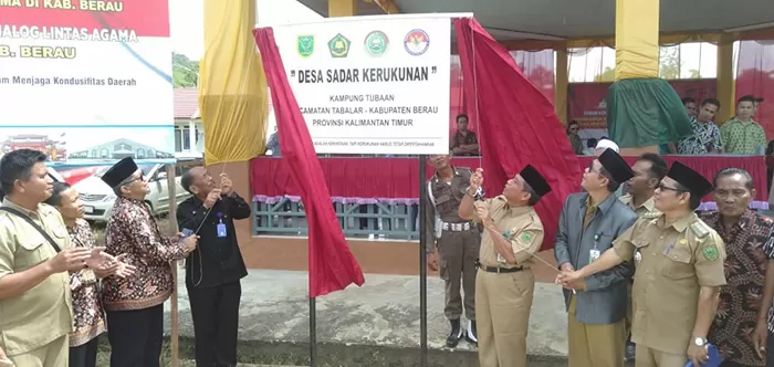 TETAPKAN: Assisten II Setda Berau Mansyah Kelana, membuka papan nama sebagai tanda penetapan Tubaan sebagai kampung sadar kerukunan.