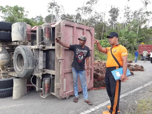 TIDAK ADA KORBAN JIWA: Aparat Polsek Derawan saat berada di TKP truk pengangkut TBS kelapa sawit yang terguling di poros Tanjung Batu kemarin.