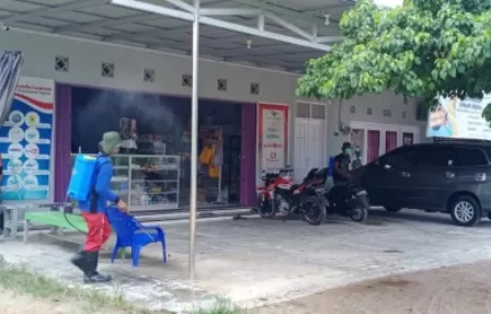 CEGAH PENYEBARAN: Petugas melakukan penyemprotan disinfektan di sejumlah rumah warga di Kampung Labanan Makmur.