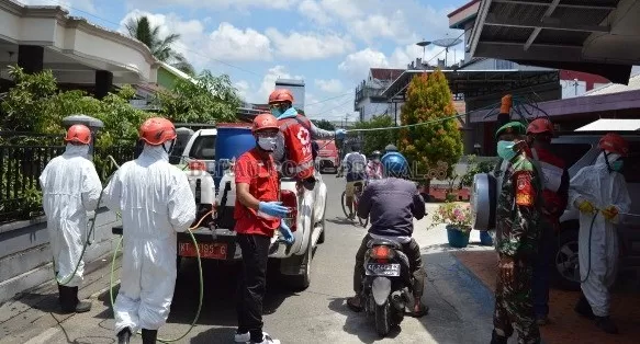 SASAR PERMUKIMAN: Relawan PMI Berau saat melakukan penyemprotan disinfektan di Gang Nangka, Tanjung Redeb, kemarin (16/4).