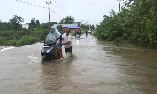 MELUAP: Luapan air Sungai Aru membuat lalu lintas di Jalan Seokarno Hatta, Talisayan, sempat terganggu. Luapan air juga merendam satu rumah warga.