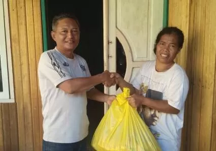 PAKET SEMBAKO: Ketua RT 7 Mulyadi memberikan bantuan sembako kepada salah satu warganya, Selasa (21/4).