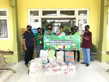 SERAHKAN BANTUAN: Perwakilan manajemen PT Resty Nur menyalurkan bantuan paket sembako untuk warga di Kelurahan Gunung Panjang dan Kampung Rantau Panjang.
