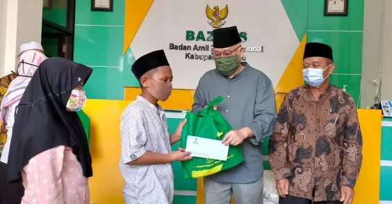 PAKET SEMBAKO: Wakil Bupati Berau Agus Tantomo secara simbolis menyerahkan bantuan paket sembako dari Baznas kepada anak yatim.