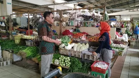 HARGA BELUM STABIL: Salah seorang pedagang sayur di Pasar Sanggam Adji Dilayas saat melayani pembeli, beberapa waktu lalu.