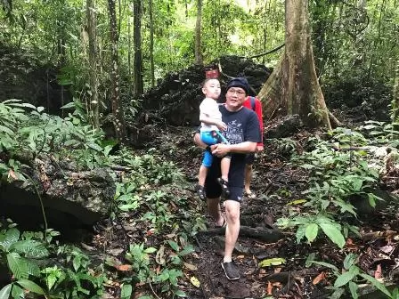 MENANTANG: Wabup Berau Agus Tantomo, menggendong anaknya saat menyusuri hutan untuk sampai ke Danau Nyadeng di pedalaman Merabu.