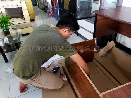 PENJUALAN MENURUN: Salah satu pekerja di Toko Mebel Citra Indah, tengah merakit meja yang hendak dijual.