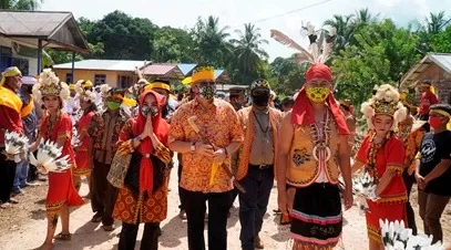 DISAMBUT: Wabup Berau Agus Tantomo bersama Ketua DPRD Madri Pani disambut dengan prosesi masyarakat Suku Dayak Basap di Kampung Suaran.
