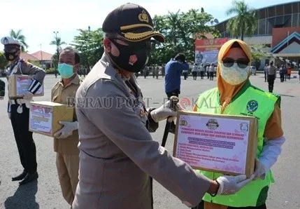 BAGIKAN MASKER: Kapolres Berau AKBP Edy Setyanto Erning Wibowo menyerahkan masker kepada perwakilan satuan yang akan dibagikan kepada masyarakat.