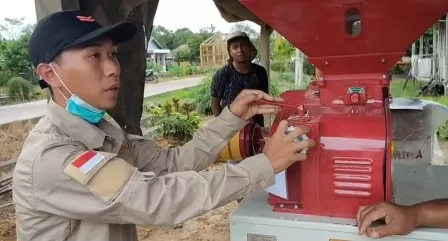 UJI COBA: Seorang teknisi saat melakukan uji coba mesin pengupas kulit padi dan pencerah beras yang dihibahkan Distanak Berau ke kelompok tani di Kampung Tasuk.