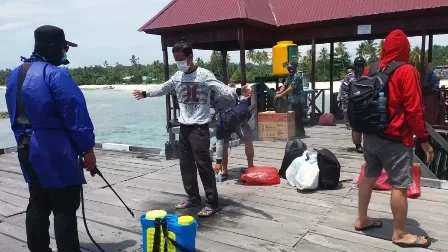 PROTOKOL KESEHATAN: Petugas menyemprotkan cairan disinfektan kepada wisatawan yang baru tiba di Pulau Maratua, beberapa waktu lalu.