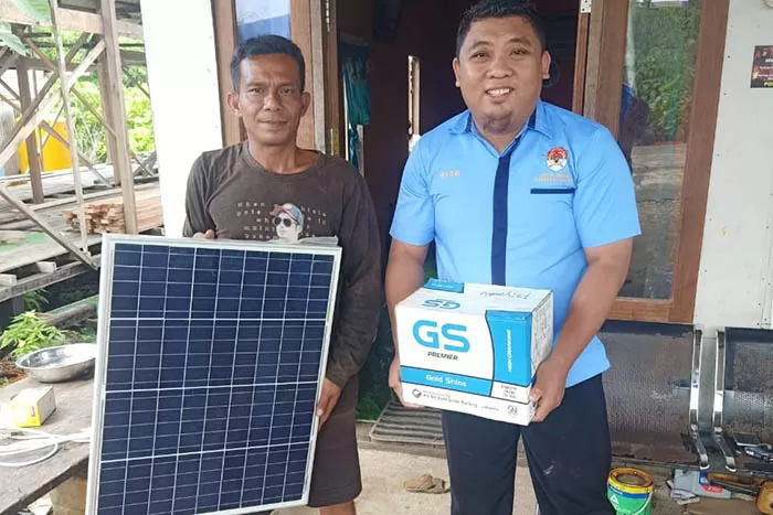 PENUHI KEBUTUHAN LISTRIK: Kasi Pelayanan Kantor Kampung Payung-Payung, Rico, menyerahkan panel surya kepada masyarakat. Program ini untuk memenuhi kebutuhan listrik masyarakat.