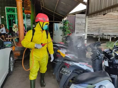 CEGAH COVID: Petugas PMI Berau yang bekerja sama dengan PT SIS Site BMO saat melakukan penyemprotan cairan disinfektan di Kampung Pegat Bukur, Sambaliung, kemarin (25/11).