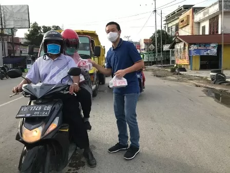 HUT PERTAMA: Landlord  KFC Cabang Berau Hendri Oetomo saat membagikan paket 200 boks KFC kepada masyarakat di simpang Jalan Pemuda, Minggu (29/11).