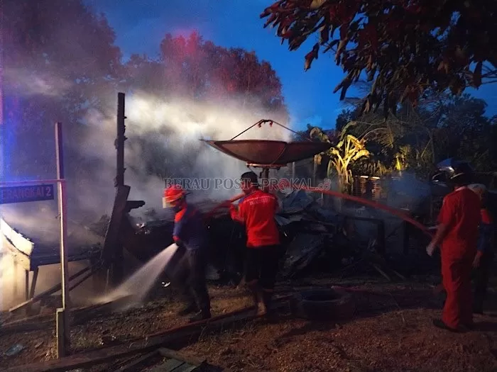Petugas pemadam kebakaran dari BPBD Berau, mendinginkan sisa bangunan rumah yang terbakar, Jumat (4/12) pukul 18.00 Wita.