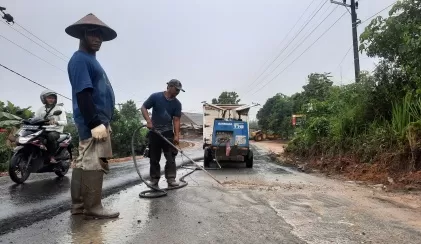 KEJAR WAKTU: Meski diguyur hujan, pelaksanaan pekerjaan proyek preservasi di ruas Jalan SM Bayanuddin, Kelurahan Sambaliung terus berjalan, kemarin (12/12).