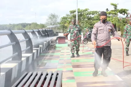 PENYEMPROTAN: Petugas TNI dan kepolisian saat melakukan penyemprotan disinfektan di Tepian Gunung Tabur beberapa waktu lalu.