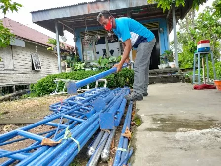 MANFAATKAN DANA RT: Ketua RT 1, Kelurahan Gunung Tabur Darmili ketika melakukan penyusunan tiang tarup yang bisa dimanfaatkan warganya secara gratis.
