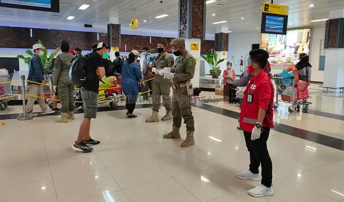 CEK PENUMPANG: Tim Satgas Penanganan Covid-19 menjaga pintu terminal kedatangan dan keberangkatan Bandara Kalimarau.
