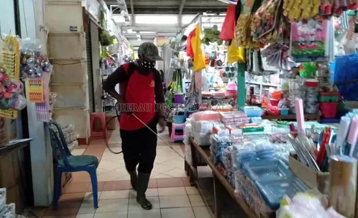 RUTIN: Sejumlah petugas menyemprot setiap sudut di Pasar Sanggam Adji Dilayas dengan cairan disinfektan.