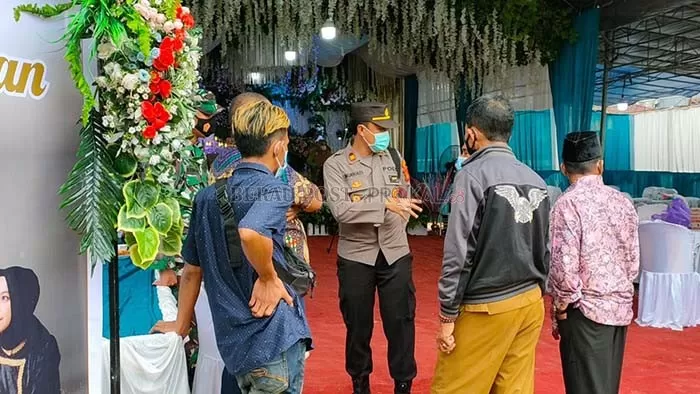 PATUHI PROKES: Lurah Karang Ambun Arif Mulyono bersama Satgas kelurahan dan kecamatan, saat menyarankan penyelenggara resepsi untuk menghentikan acara.