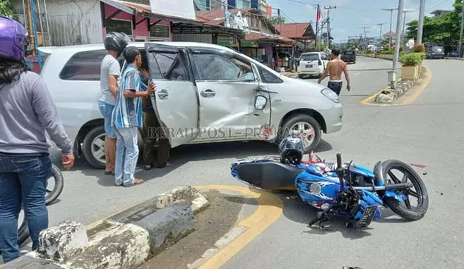 EVAKUASI: Sejumlah warga saat mengevakuasi pengemudi sepeda motor untuk dilarikan ke rumah sakit, usai menabrak bagian kanan mobil.