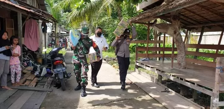 BERIKAN BANTUAN: Tim Kelurahan Tanjung Redeb bersama aparat TNI-Polri saat menyalurkan bantuan logistik kepada masyarakat yang menjalani isolasi mandiri, Rabu (24/2).