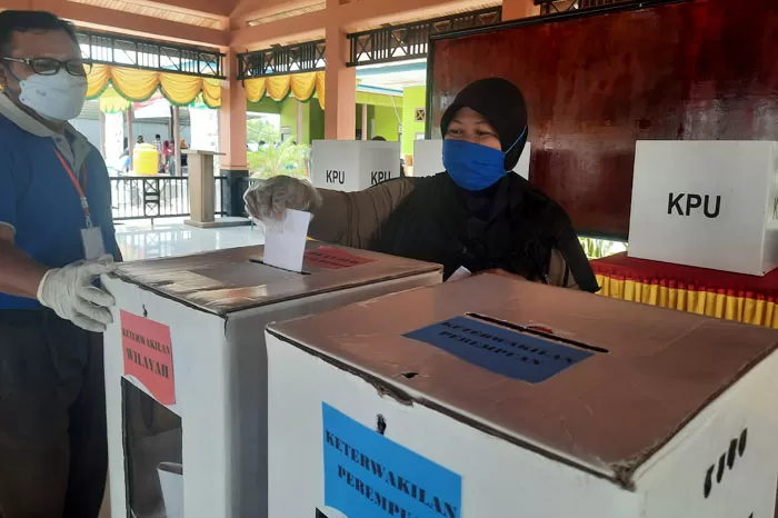 ANTUSIAS: Salah satu masyarakat menyimpan surat suara di kotak yang telah disediakan.