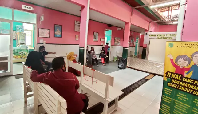 MENGANTRE: Masyarakat yang sedang menunggu di ruangan tunggu Puskesmas Bugis untuk melakukan pelayanan kesehatan.