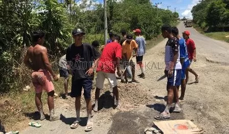 CEGAH KECELAKAAN: Komunitas Orang Muda Katolik (OMK) Kampung Siduung Indah saat melakukan perbaikan jalan di kampungnya secara swadaya.
