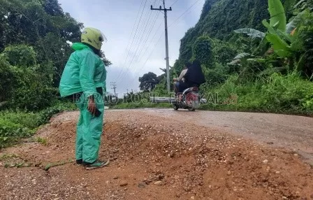 MENURUN: Ruas jalan di Kampung Gurimbang yang semakin menurun.