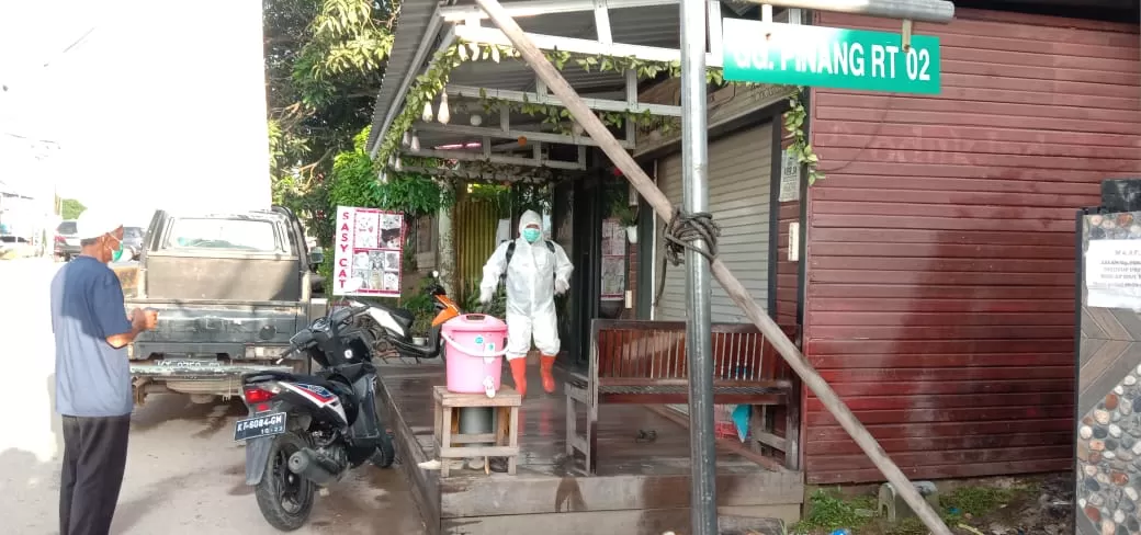 PENYEMPROTAN: Satgas Kelurahan Sambaliung saat melakukan penyemprotan disinfektan di rumah warga yang meninggal disertai Covid-19.