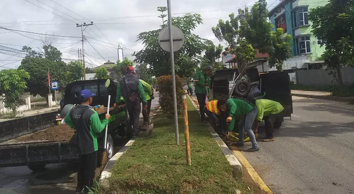 BERSIH-BERSIH: Petugas kebersihan serta pertamanan, DLHK Berau, menata taman dan membersihkan drainase di Jalan Gatot Subroto, Selasa (25/5).