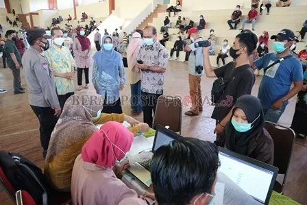 TINJAU VAKSINASI MASSAL: Bupati Berau Sri Juniarsih, tampak mendampingi salah seorang warga yang mengikuti vaksinasi massal, kemarin (12/6).