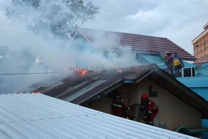 TUNGGU LISTRIK PADAM: Petugas pemadam kebakaran berjibaku memadamkan api yang membakar atap rumah warga di Jalan Teuku Umar, Rabu (6/10) kemarin.