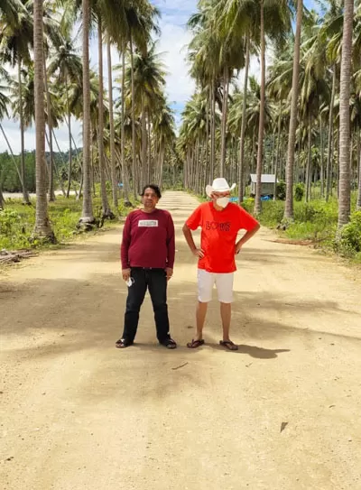 LINGKUNGAN ASRI: Oetomo Lianto bersama rekannya, berfoto di tengah-tengah jejeran pohon kelapa di Kampung Teluk Sumbang, sebelum berkunjung ke Lamin Guntur.