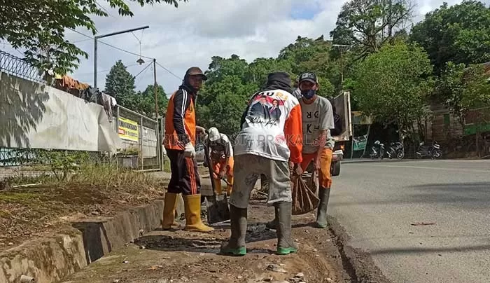 BERSIHKAN DRAINASE: Petugas kebersihan DLHK Berau saat melakukan pengangkatan sedimentasi di drainse Jalan Pulau Sambit, Tanjung Redeb, beberapa waktu lalu.
