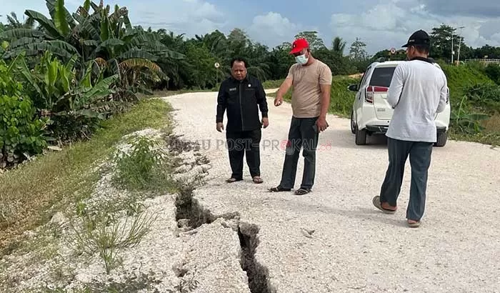 TINJAU: Ketua DPRD Berau Madrid Pani, saat meninjau jalan yang menghubungkan tiga kampung dengan Kecamatan Tanjung Redeb yang ambles di RT 1 Kampung Tumbit Dayak.