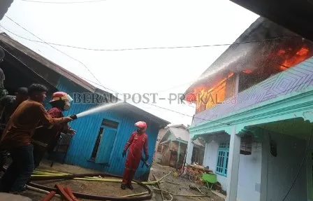 BERUSAHA PADAMKAN API: Petugas pemadam kebakaran berusaha memadamkan api yang cepat meluas di kawasan padat penduduk, Jalan Pulau Sambit, Tanjung Redeb, Sabtu (15/1).