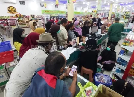 ANTREAN: Sejumlah masyarakat saat mengantre membeli minyak goreng di salah satu toko ritel di wilayah Tanjung Redeb.