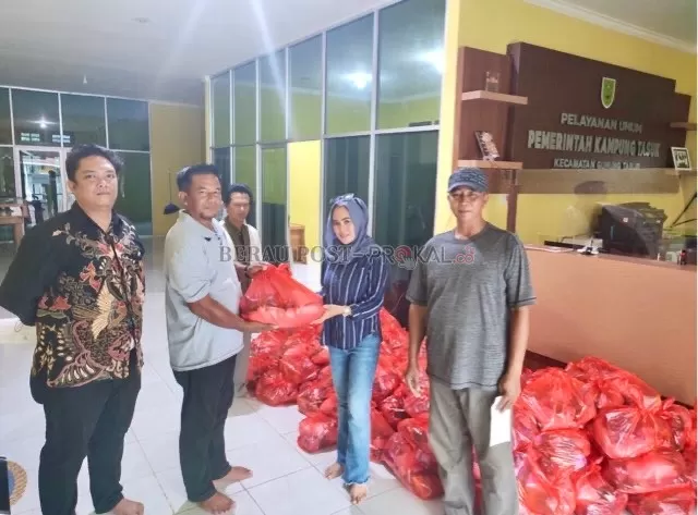 SERAHKAN BANTUAN: Manajer Humas KLK Kaltim Region Jupita (dua kanan) saat menyerahkan bantuan sembako paket Lebaran kepada perwakilan warga Kampung Tasuk, Sabtu (22/4) lalu.