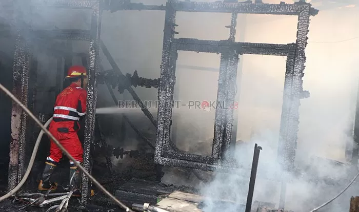 BERJIBAKU: Petugas pemadam kebakaran berusaha memadamkan api yang menghanguskan 3 ruko, 1 rumah,  dan indekos 23 pintu, di Jalan Pulau Panjang kemarin (23/6).
