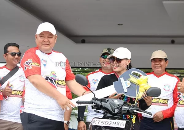 HADIAH UTAMA: Owner A-News, Nugrahi Mawan, menyerahkan hadiah utama sepeda motor kepada peserta jalan sehat yang beruntung, dalam perayaan HUT ke-2 A-News kemarin (11/9).